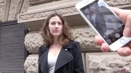 Alessandra steht lächelnd mit lockigem Haar vor einem Berliner Altbau in der Sonne