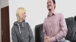 Blonde Schwester in grauem Hoodie greift ihrem Bruder auf der Ledercouch zwischen die Beine