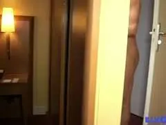 Blonde Milf mit weißen Top und Jeans liegt lasziv auf dem Hotelbett und schaut direkt in die Kamera