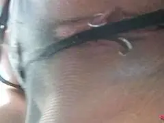 Schwarzhaarige Nylonfrau mit Brille spreizt ihre Beine und fingert ihre nasse Muschi