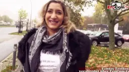 Lachende mollige Blondine mit Tattoo und Schal steht outdoor auf herbstlichem Parkplatz