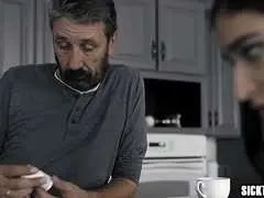 Nahaufnahme einer Hand, die einen dicken, glänzenden Penis in eine enge, rasierte Fotze schiebt.