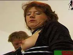 Nackte reife Milf mit Seilen gefesselt an Holzpfosten, Arme gespreizt, schwere Brüste frei